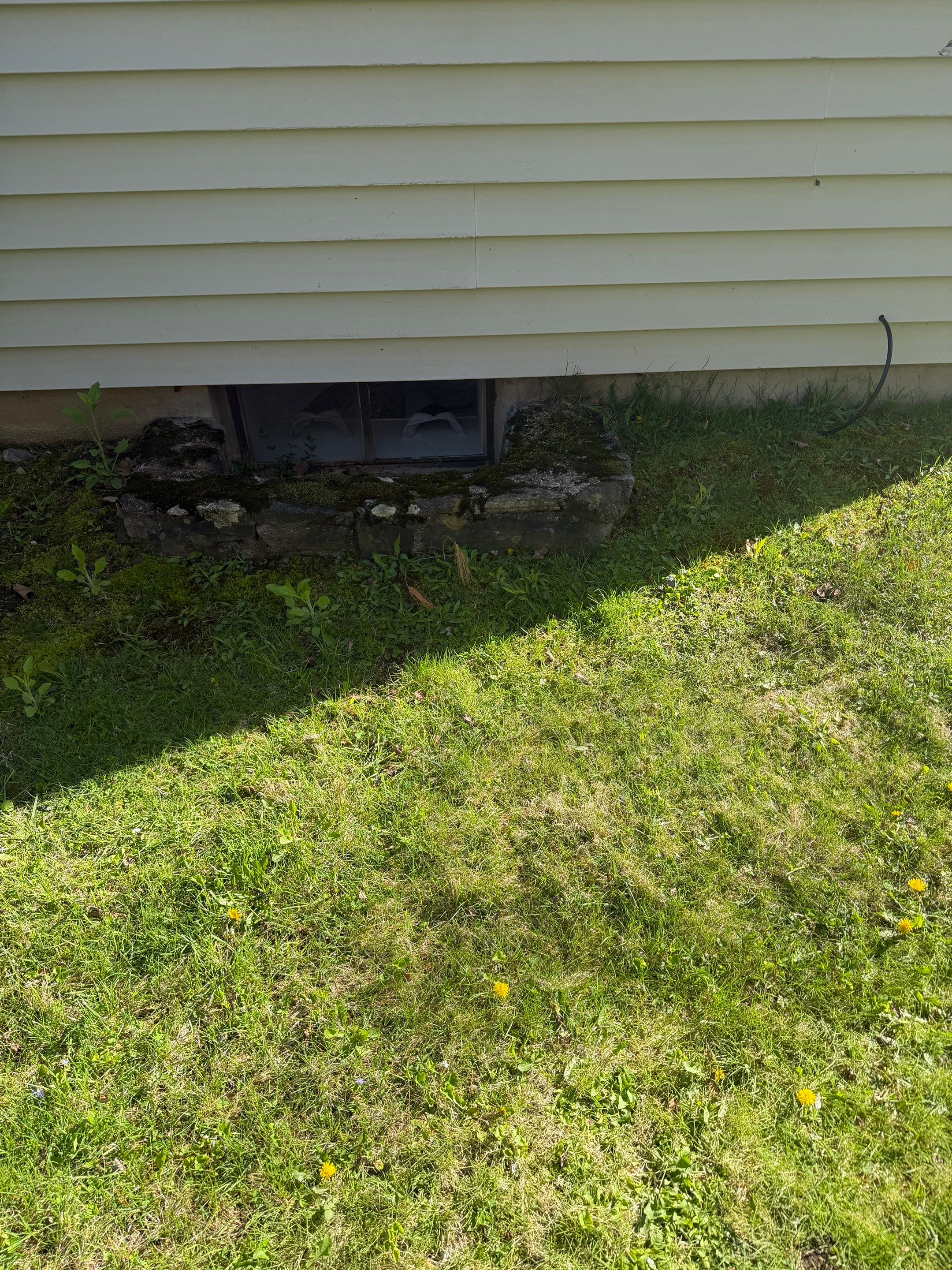 Before egress window installation in Winchester, Connecticut — exterior view